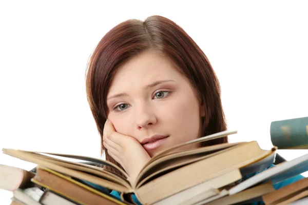 Jonge vrouw achter boeken — Stockfoto