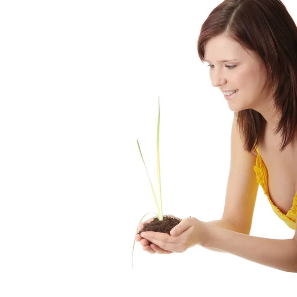 Mujer joven sosteniendo una pequeña planta y tierra —  Fotos de Stock