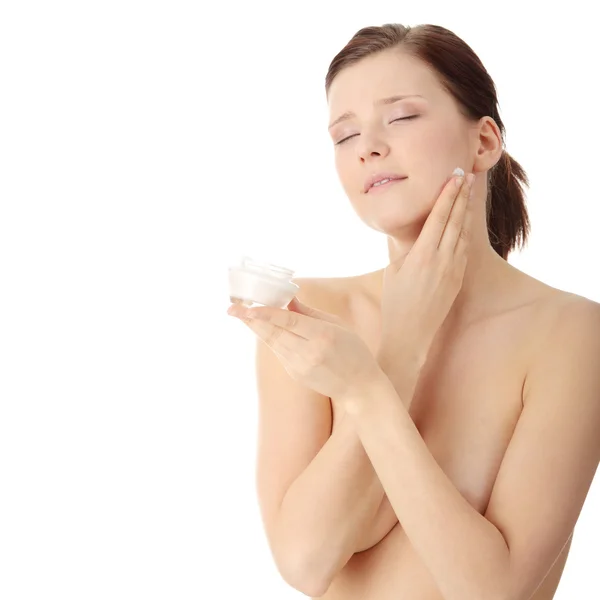 Mulher aplicando creme hidratante no rosto — Fotografia de Stock