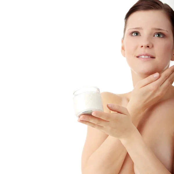 Женщина наносит крем для увлажнения на лицо — стоковое фото