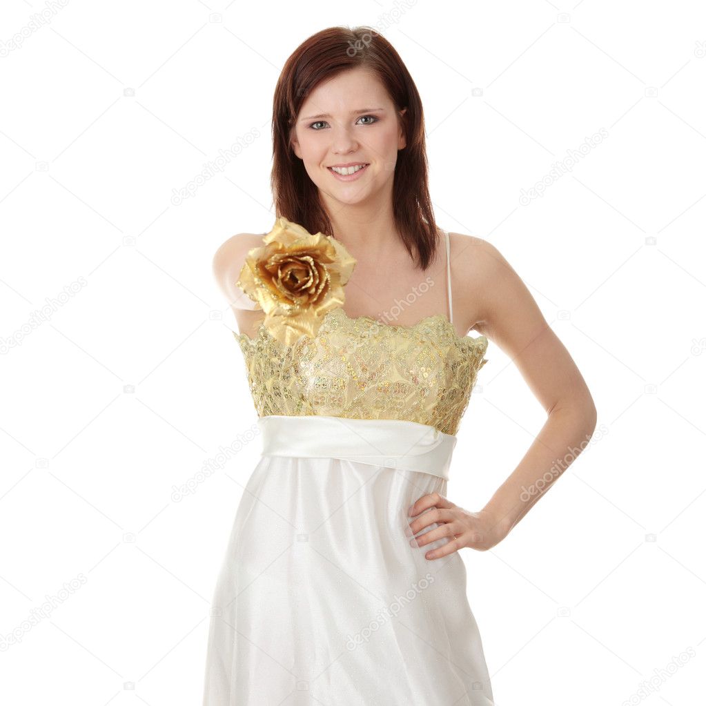 Young beautiful woman in elegant, evening, gold dress, holding gold roseisolated on white background.
