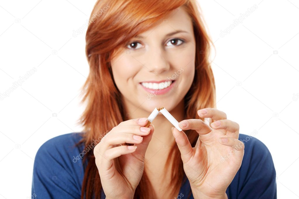 Young happy woman breaking cigarette, over white background