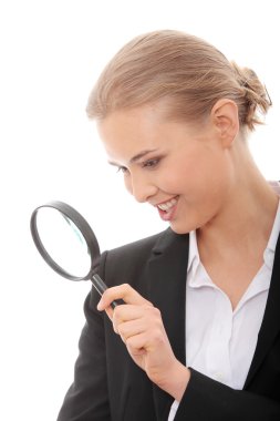 Young attractive smiling business woman looking into a magnifying glass, isolated on white background clipart