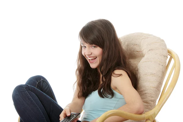 テレビからアームチェア ビューに座ってリモコンでテレビを見ている 代の女性 — ストック写真