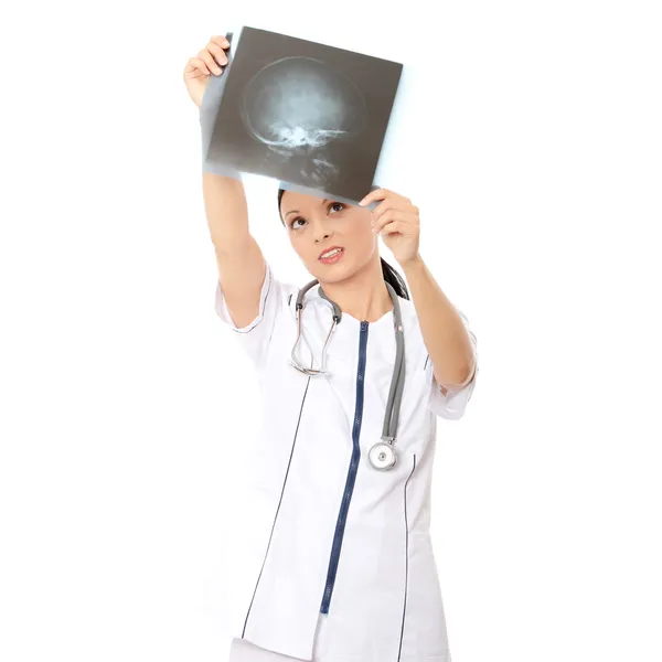 Задумчивая женщина-врач смотрит на рентгеновское изображение — стоковое фото