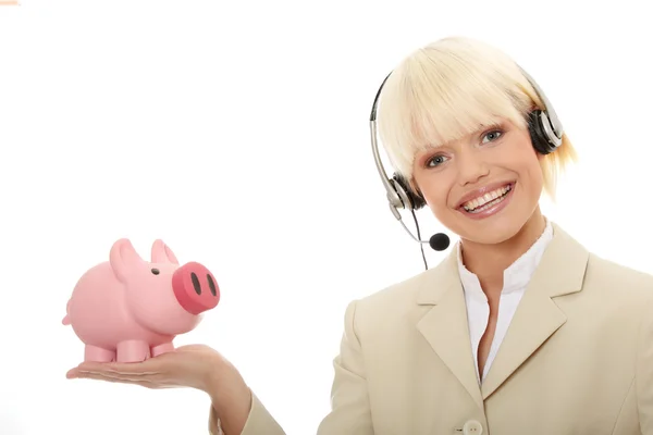貯金箱を保持しているヘッドセットを持つ若いビジネス女性 — ストック写真