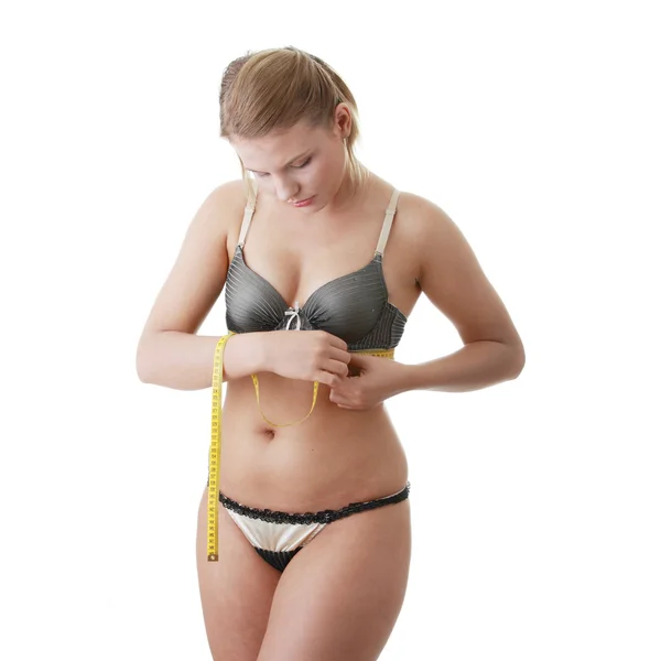 Um pouco de gordura jovem mulher mesuring seu corpo — Fotografia de Stock