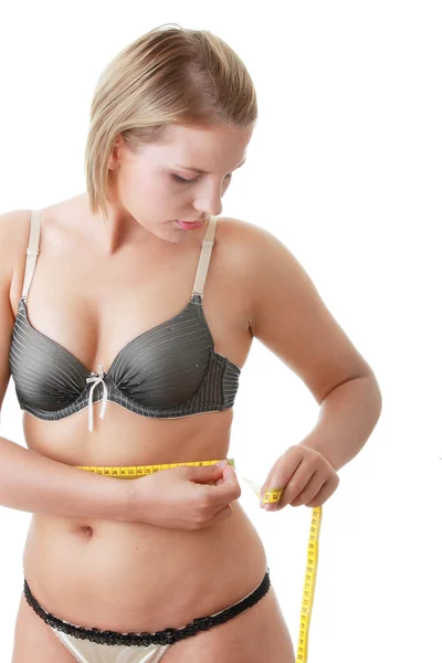 Um pouco de gordura jovem mulher mesuring seu corpo — Fotografia de Stock