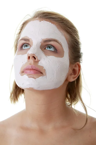 Unga kvinnliga ansikte med lera mask — Stockfoto