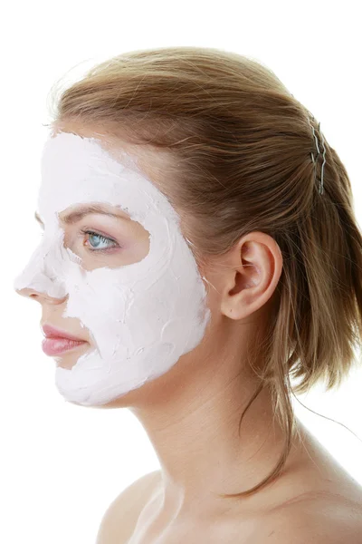 若い女性の顔に粘土の化粧品のマスク — ストック写真