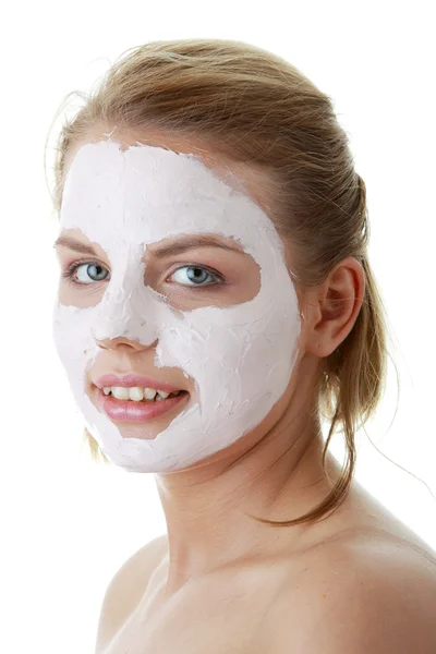 若い女性の顔に粘土の化粧品のマスク — ストック写真