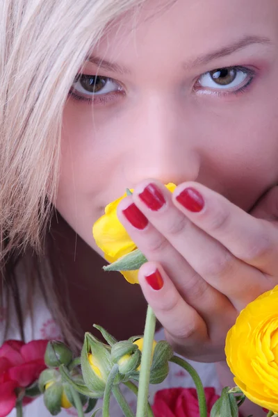 Mujer rubia escondida detrás de flores de colores —  Fotos de Stock