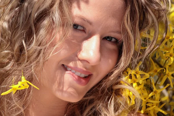 Mujer joven rubia en flores de forsythia amarillas —  Fotos de Stock