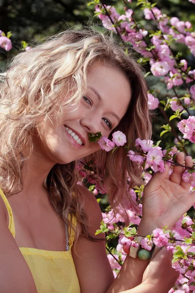 ピンクの花 ツリー間美しい金髪の女性の肖像画 — ストック写真
