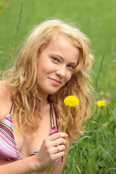 Krásná žena v trávě a květiny — Stock fotografie