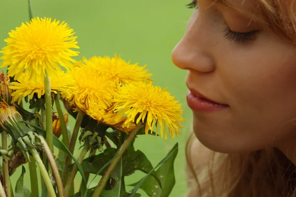 Vacker flicka i ett fält njuter av solen och att lukta flödet — Stockfoto