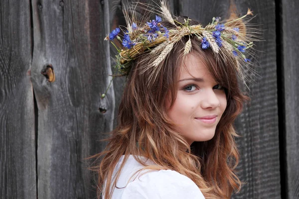 Beautiful young girl with grain wreath — Stock Photo, Image