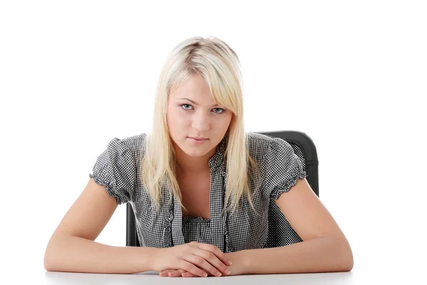 Ung kvinna sitter med händerna på skrivbord — Stockfoto