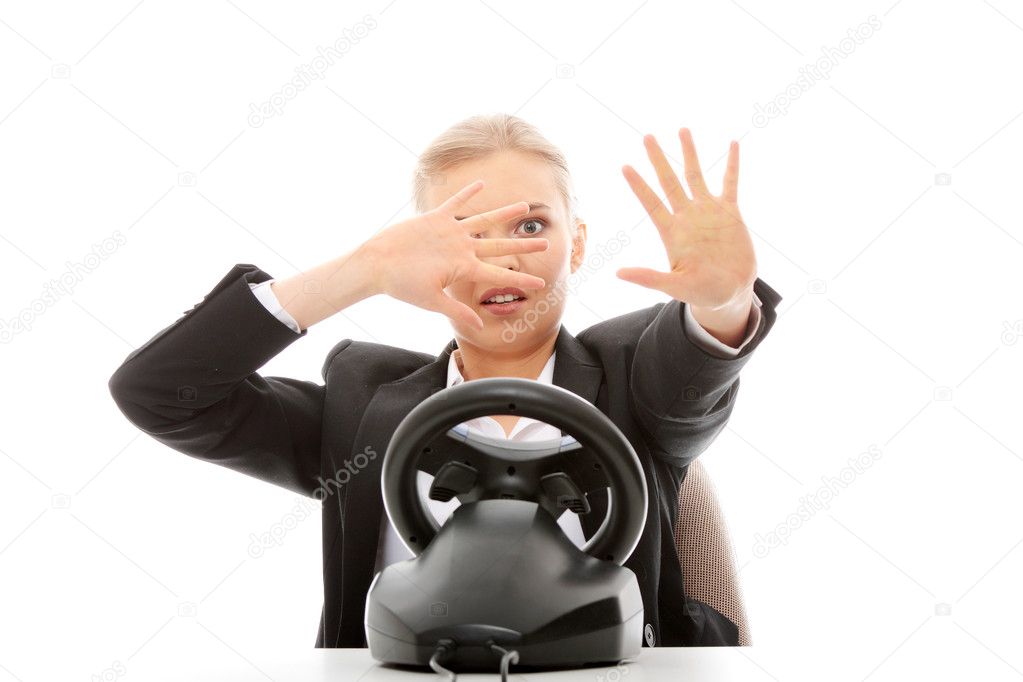 Young caucasian business woman playing on computer (with steering wheel), isolated on white background