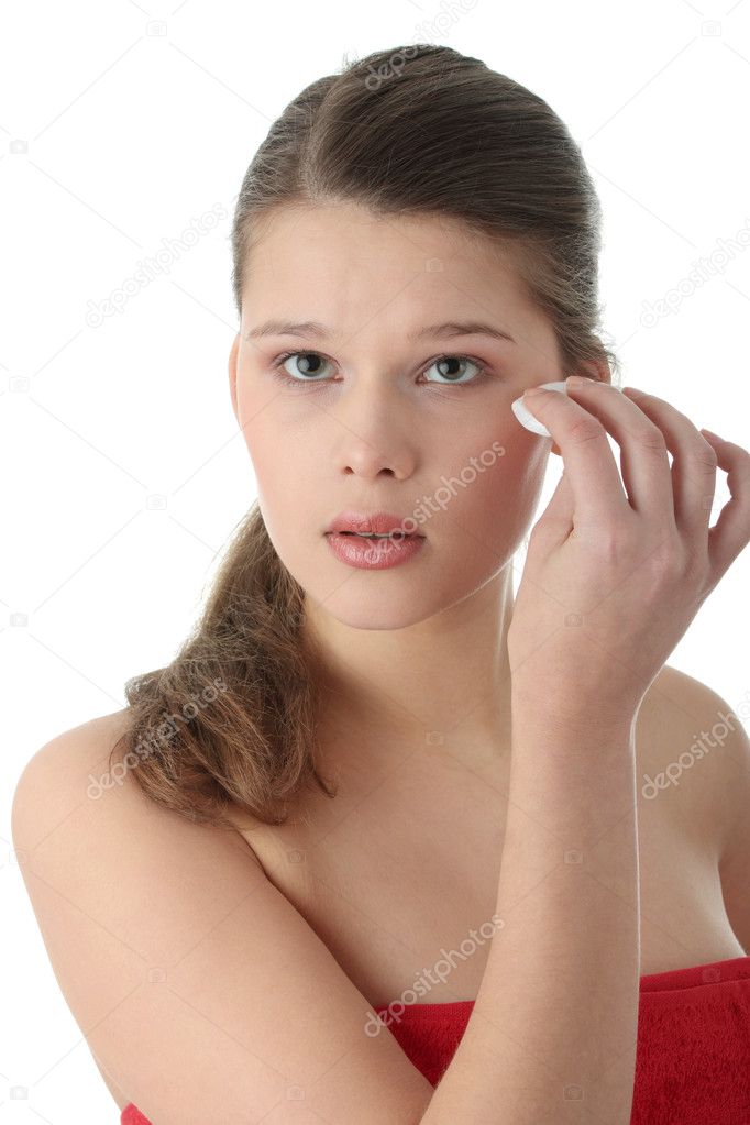 Woman cleaning her face with cotton pads