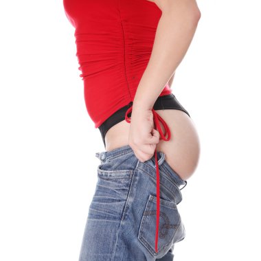 Woman trying to get in to old jeans. clipart