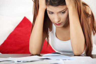 A young beautiful woman stressed because of bills. clipart