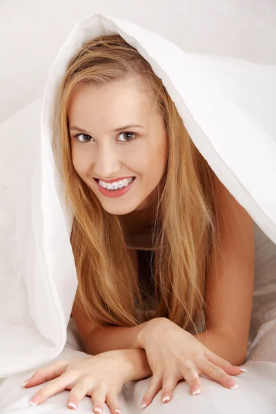 Beautiful young happy caucasian woman in bed — Stock Photo, Image