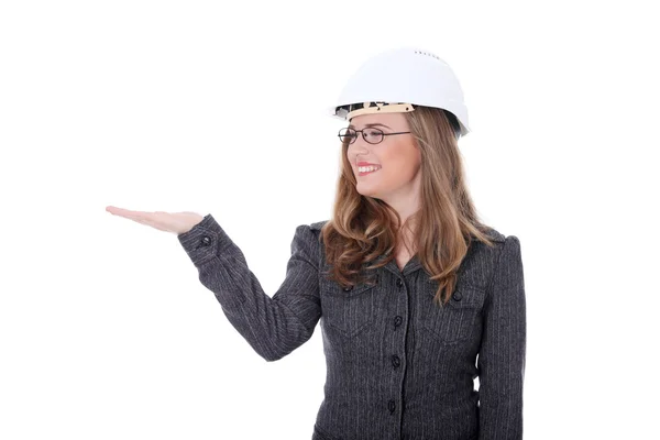 若い建築家の女性の保護用のヘルメットを着て一方で何かを提示します 白い背景で隔離 — ストック写真