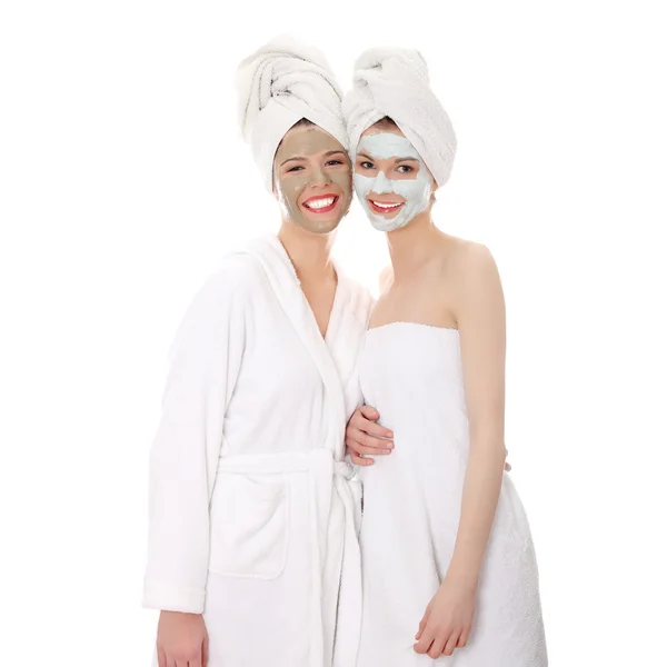 Jonge gelukkig vrouwen met gezicht klei masker — Stockfoto
