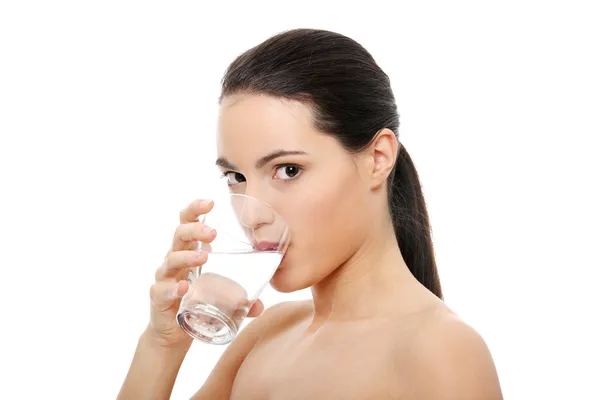Beautiful young woman drinks clear mineral water — Stock Photo, Image