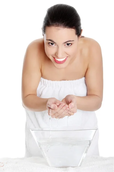 Jeune femme se lave le visage avec de l'eau claire — Photo