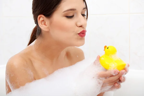 Frau badet mit gelber Ente. — Stockfoto