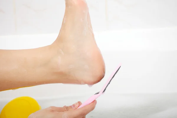 Frau in Badewanne reibt Ferse des Fußes — Stockfoto