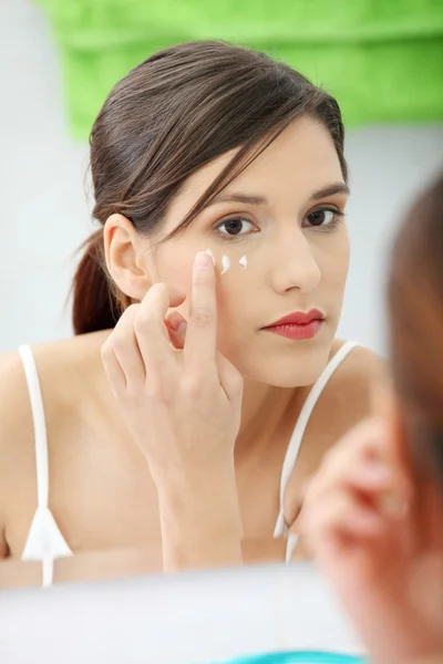 Hermosa mujer aplicando crema en la cara —  Fotos de Stock