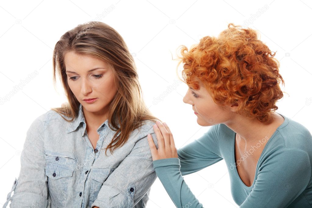 Troubled young girl comforted by her friend