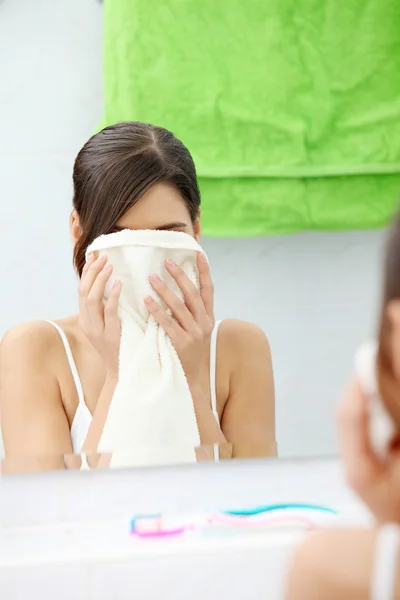 美丽的女人擦她的脸用毛巾在浴室 — 图库照片