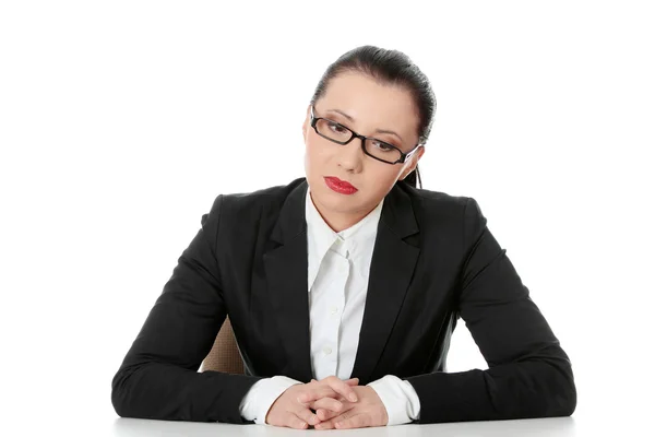 Smutna bizneswoman siedzi za biurkiem — Zdjęcie stockowe