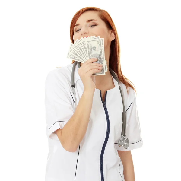 Femme médecin tenant de l'argent — Photo