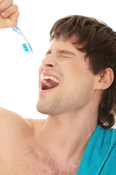 Jonge gelukkig knappe man zingen aan tandenborstel — Stockfoto