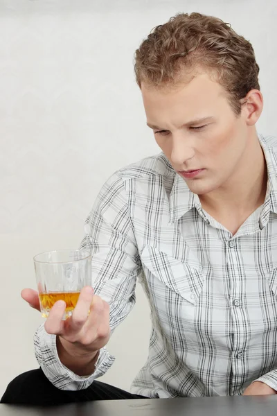Привлекательный молодой парень пьет виски — стоковое фото
