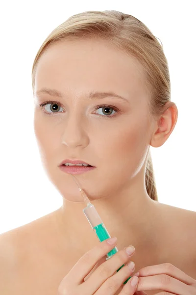 Młoda kobieta z strzykawka obok usta — Zdjęcie stockowe
