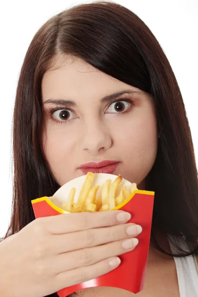 Jonge vrouw eten frietjes — Stockfoto