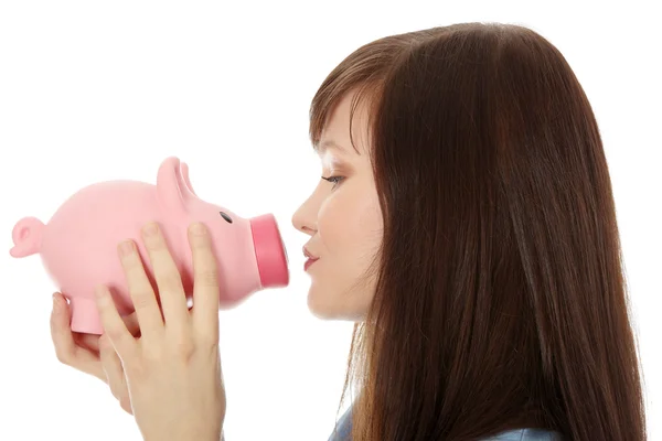 Young teen woman kissing a piggy bank — Stock Photo, Image
