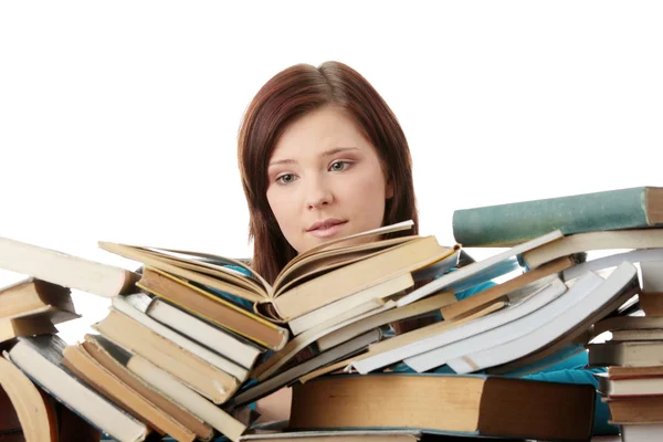 Kitapların arkasına oturan genç kadın — Stok fotoğraf