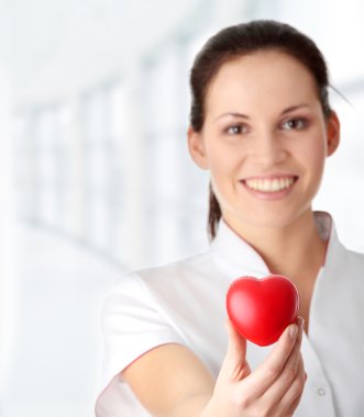 Young nurse with heart in her hand clipart