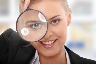 Business woman looking into a magnifying glass clipart