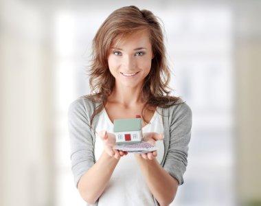 Woman holding euros bills and house model clipart