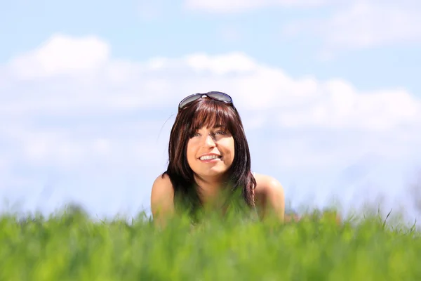 草の笑みを浮かべて、美しい若い女性 — ストック写真