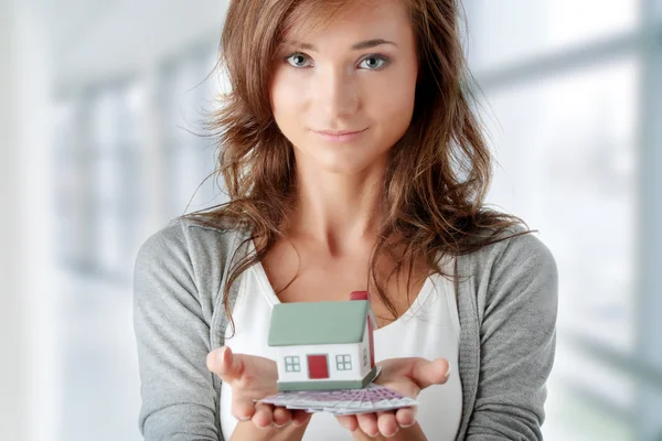 Kobieta trzyma euro rachunki i modelu dom — Zdjęcie stockowe