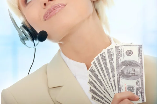 Business woman with headset holding dollars — Stock Photo, Image